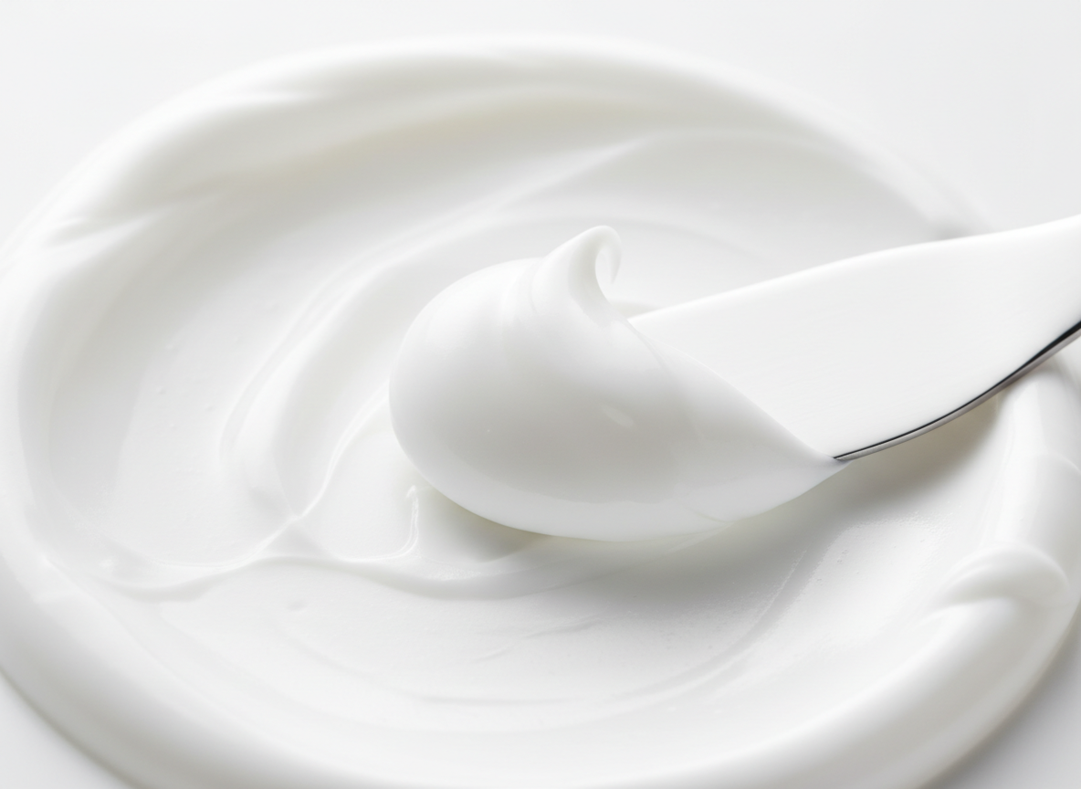 Close-up texture of smooth white lotion or cream showing rich creamy consistency